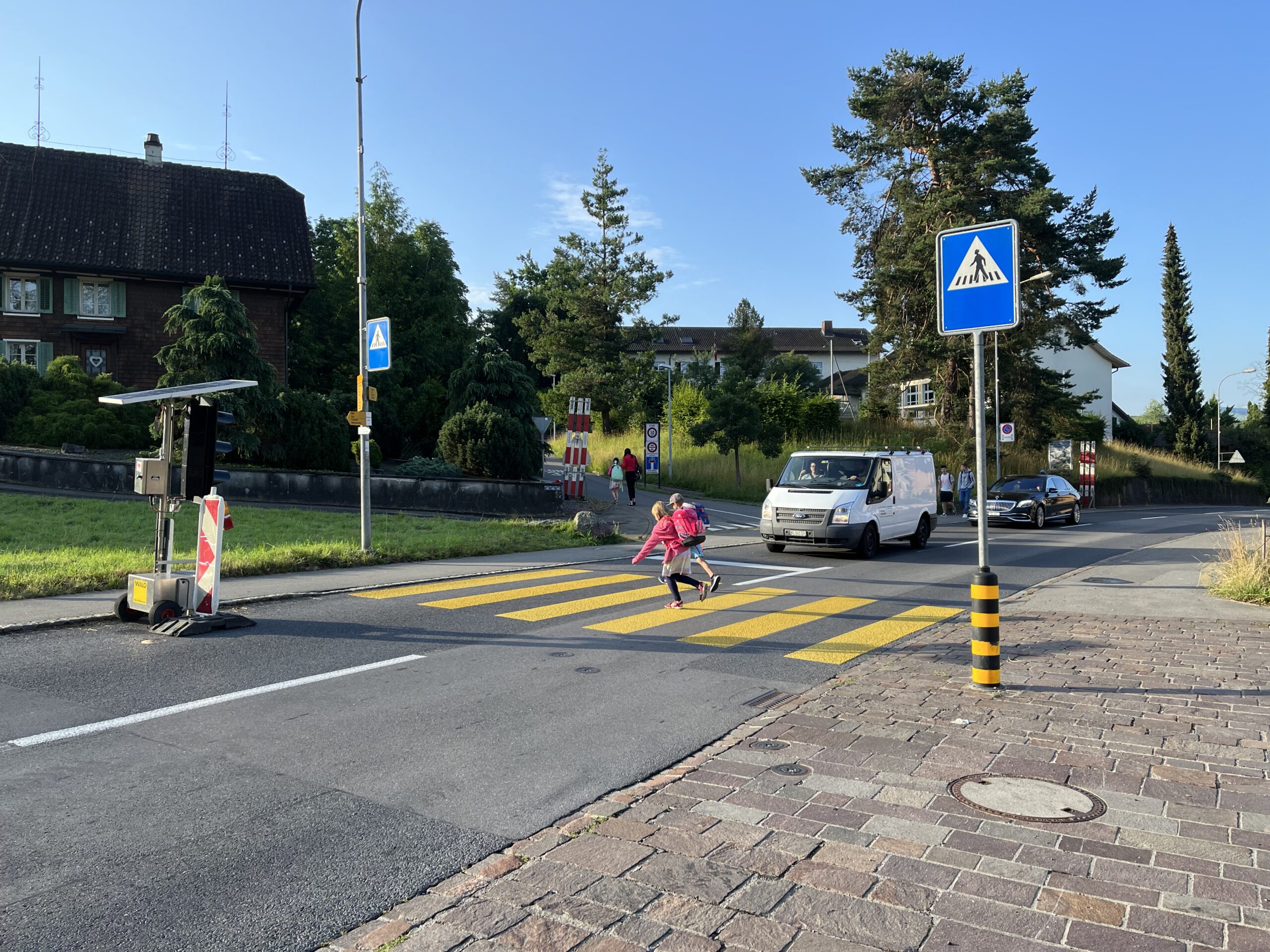 Zwei Kinder queren einen Fussgängerstreifen