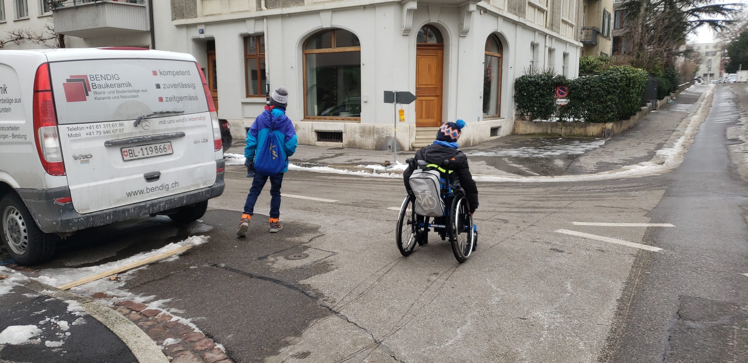 Zwei Kinderexpert:innen Queren eine Quartierstrasse bei eingeschränkter Sicht